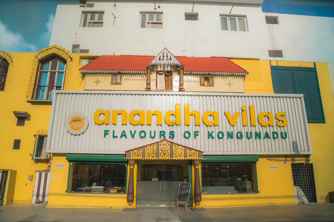 The Anandha Vilas storefront on East Coast Road: yellow building, red-tiled roof and carved wooden pillars at the entrance